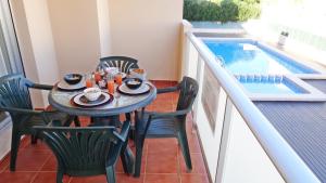 un tavolo e sedie su un balcone con piscina di SAN FERNANDO PALACE III - Beach House a Oliva