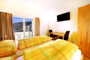 ein Hotelzimmer mit 2 Betten, einem Tisch und einem Fenster in der Unterkunft Hotel de la Gare in Sugiez
