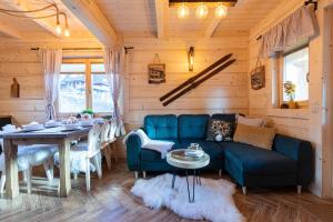 a living room with a blue couch and a table at TatryTop Osada Gazdówka z sauną in Kościelisko