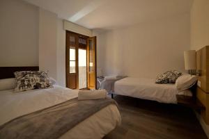Cette chambre comprend 2 lits et une fenêtre. dans l'établissement Alojamientos barrio humedo Plaza Mayor 1, à León