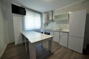 a kitchen with a white table and a white refrigerator at Alojamientos barrio humedo Plaza Mayor 1 in León