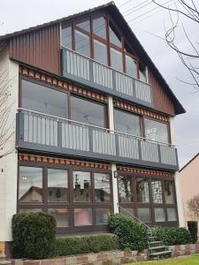 une maison avec un balcon au-dessus dans l'établissement Ferienwohnung Sirch, à Diedorf