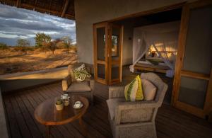 a room with a table and chairs and a bed at Manyara's Secret in Mto wa Mbu