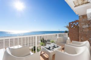 a balcony with white chairs and a view of the beach at Higuerón Rental Playa Apartamento in Benalmádena