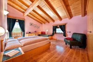 a bedroom with a large bed and a chair at Appartamenti Duc De Rohan in Livigno
