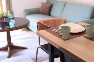 a table with a plate and two cups on it at Apartman Casa Skerlak in Malo Središte