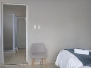 a bedroom with a chair and a bed and a mirror at Beechwood B&B in Durban