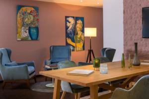Four Stars by City Hotel في مكنهايم: قاعة اجتماعات مع طاولة وكراسي خشبية