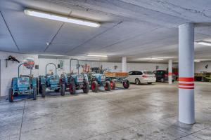 uma garagem com vários tractores estacionados nela em Hotel Stefanie em Tirolo