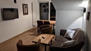 ein Wohnzimmer mit einem Sofa, Stühlen und einem Tisch in der Unterkunft Ferienhaus Wetterstein in Grainau