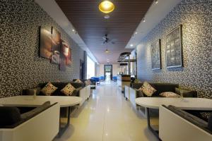 a restaurant with tables and couches and a hallway at Royal Darmo Malioboro in Yogyakarta