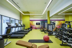 a gym with treadmills ellipticals and exercise equipment at Riu Dubai Beach Resort - All Inclusive in Dubai