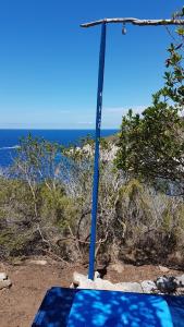 un poste azul en la playa con el océano en el fondo en islandescape-bisevo, en Isla Biševo