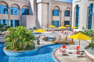 Gewan Hotel Cairo في القاهرة: منتجع فيه مسبح وبه كراسي ومظلات