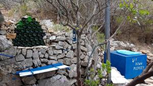 una pila de botellas verdes en una pared de piedra en islandescape-bisevo en Biševo