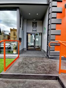 un accès à un bâtiment avec une porte orange dans l'établissement Refresh109 on Cameron, à Launceston