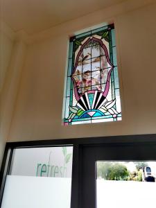 a stained glass window above the door of a church at Refresh109 on Cameron in Launceston