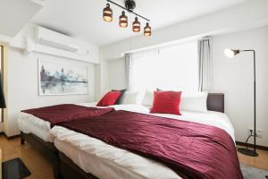 東京にあるHOTEL AIS HATAGAYAのベッドルーム1室(大型ベッド1台、赤い枕付)