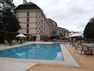 a hotel with a swimming pool in front of a building at Flat em Pedra Azul in Pedra Azul