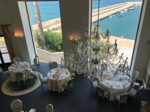 a dining room with two tables and a chandelier at Marina Holiday & Spa in Balestrate