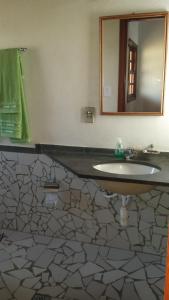 a bathroom with a sink and a mirror at Pousada Chico Taquara in São Thomé das Letras