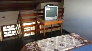 a television sitting on a table in a room at Pousada Chico Taquara in São Thomé das Letras