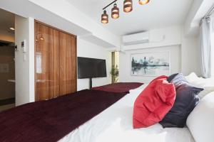 東京にあるHOTEL AIS HATAGAYAのベッドルーム1室(大型ベッド1台、赤い枕付)