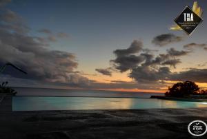 a sunset over a body of water with a sign at House Rodrigues in Água de Pau