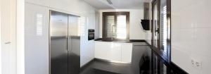 a kitchen with white walls and a black and white refrigerator at Bodega Don Balbino in La puebla de Labarca  +6 photos