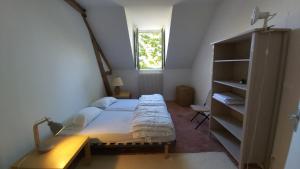 Un dormitorio con una cama y un escritorio y una ventana. en LA PINÇONNIERE, en Verneuil-sur-Indre