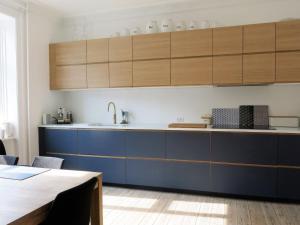 コペンハーゲンにあるApartmentInCopenhagen Apartment 414のキッチン(青いカウンター、木製キャビネット付)
