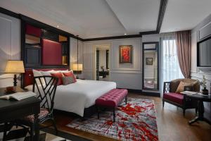 um quarto com uma cama grande, uma secretária e uma cadeira. em Aira Boutique Hanoi Hotel & Spa em Hanói