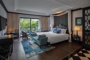 a bedroom with a large bed and a living room at Aira Boutique Hanoi Hotel & Spa in Hanoi