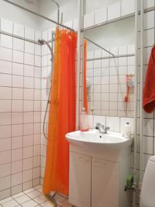 uma casa de banho com uma cortina de chuveiro laranja ao lado de um lavatório em ApartmentInCopenhagen Apartment 931 em Copenhague