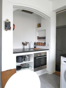 La cuisine est équipée de comptoirs blancs et de plaques de cuisson. dans l'établissement ApartmentInCopenhagen Apartment 980, à Copenhague