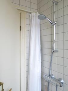 a shower with a white shower curtain in a bathroom at ApartmentInCopenhagen Apartment 980 in Copenhagen