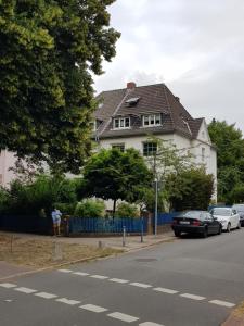 una casa con una valla azul y coches aparcados en la calle en Ganze Wohnung mit Garten, en Bremen