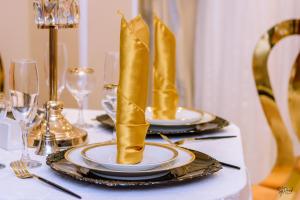 a table with two plates and gold boots on top at Hôtel La Principauté Douala Bonapriso in Douala