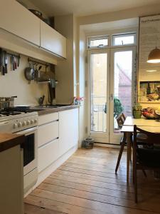 コペンハーゲンにあるApartmentInCopenhagen Apartment 1107のキッチン(コンロ、テーブル付)、窓が備わります。