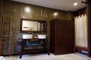 Zimmer mit einem Spiegel und einem Holzschrank in der Unterkunft Sunny V Hotel in Chiang Mai