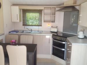 eine Küche mit Spüle und Herd Oberer Backofen in der Unterkunft RBR 211 - Beach Resort Kamperland in Kamperland