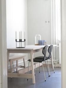 Una mesa blanca con dos sillas y velas. en ApartmentInCopenhagen Apartment 1141, en Copenhague