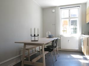 una cocina con una mesa de madera con tres velas. en ApartmentInCopenhagen Apartment 1141, en Copenhague