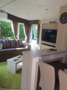 Wohnzimmer mit Sofa und TV in der Unterkunft RBR 211 - Beach Resort Kamperland in Kamperland