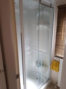 eine Glasdusche im Bad mit Waschbecken in der Unterkunft RBR 211 - Beach Resort Kamperland in Kamperland