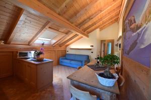 a kitchen and living room with a blue couch at Casa Caste in Bormio