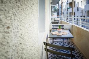 a small table and chairs on a balcony at Bauhaus Living with Amazing Roof Top by Sea N' Rent in Tel Aviv