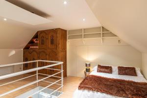 a attic bedroom with a bed and a staircase at Maison Noppius - Love Hotel in Liège