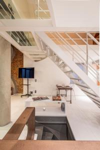 a living room with a staircase and a table at Maison Noppius - Love Hotel in Liège