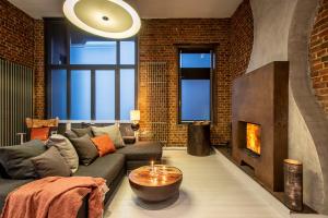 a living room with a couch and a fireplace at Maison Noppius - Love Hotel in Liège